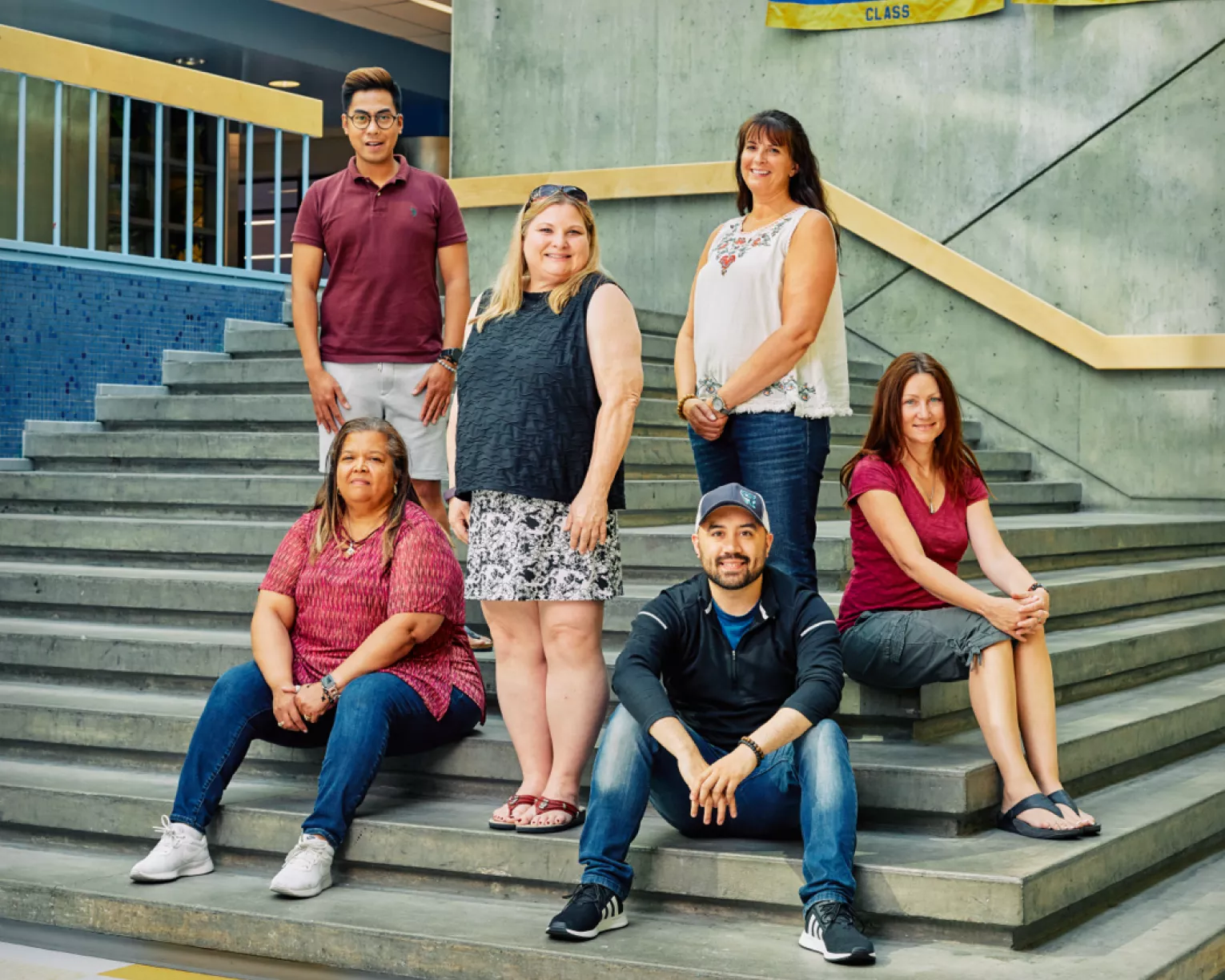 NEA-Alaska Members pose sitting on concrete stairs.
