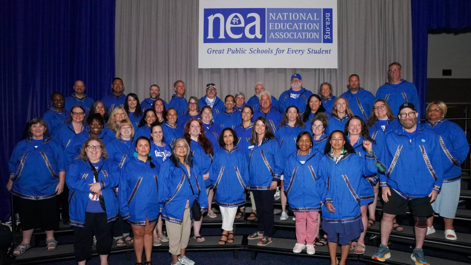 A group of NEA-Alaska members in blue Kuspuk's at RA.