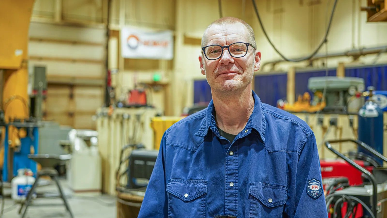 Pete Daley Poses in his welding shop at Hutchinson HS