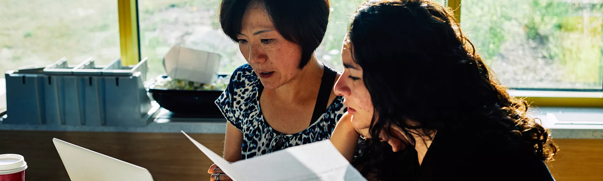 Two female teachers collaborate on lesson plans.