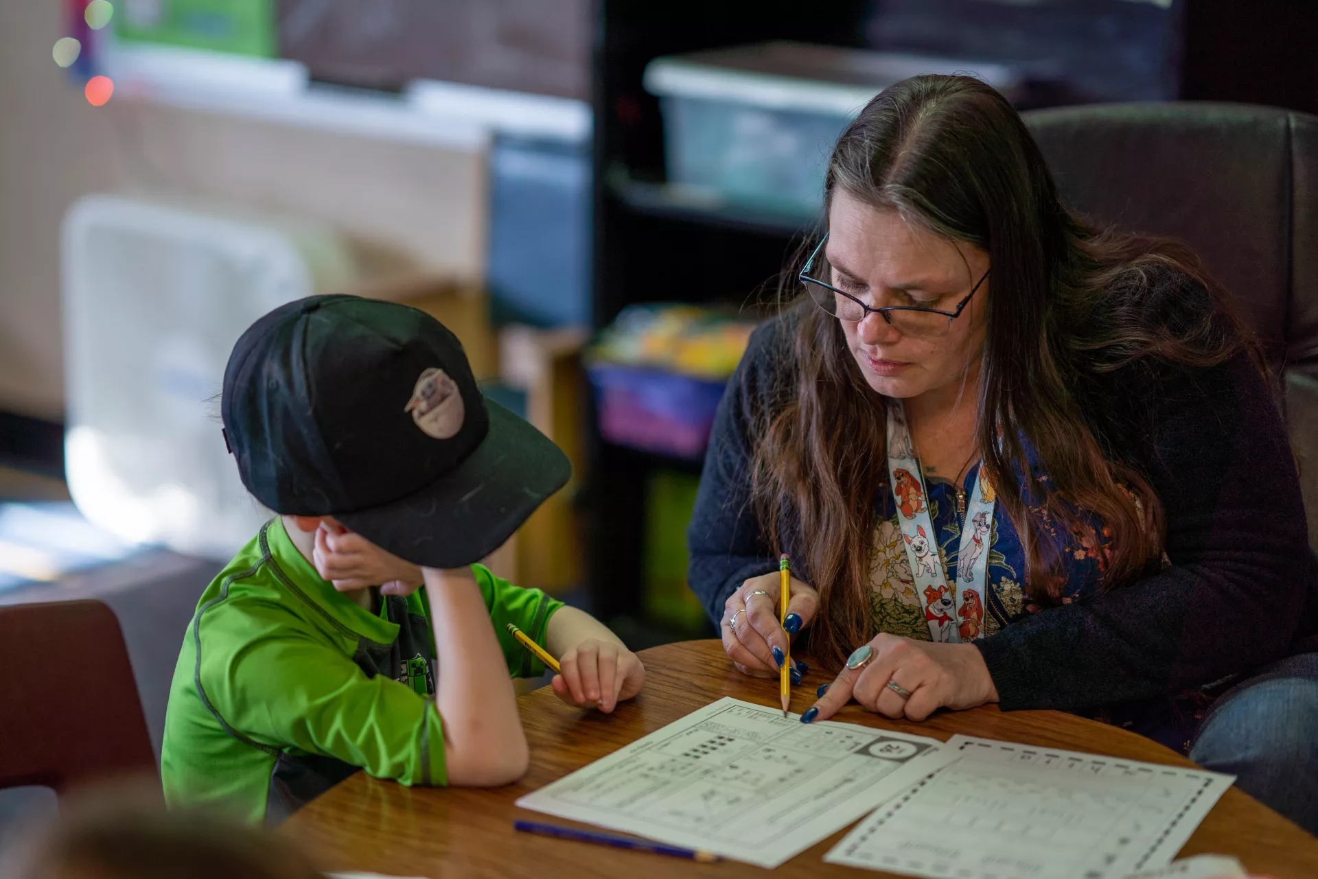 A paraeducator works on a homework assignment with a young student.