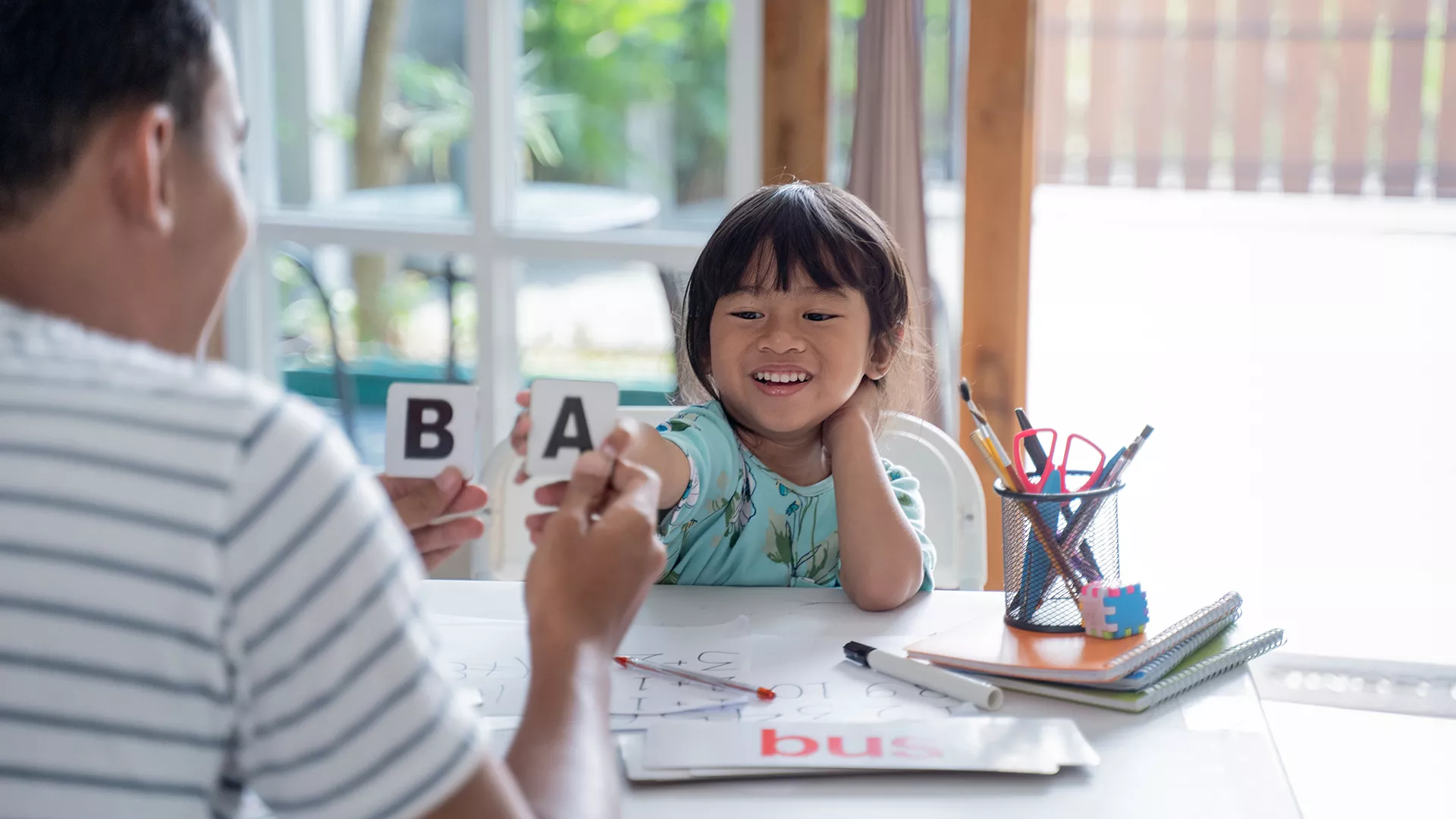 young girl learning phonics with her father