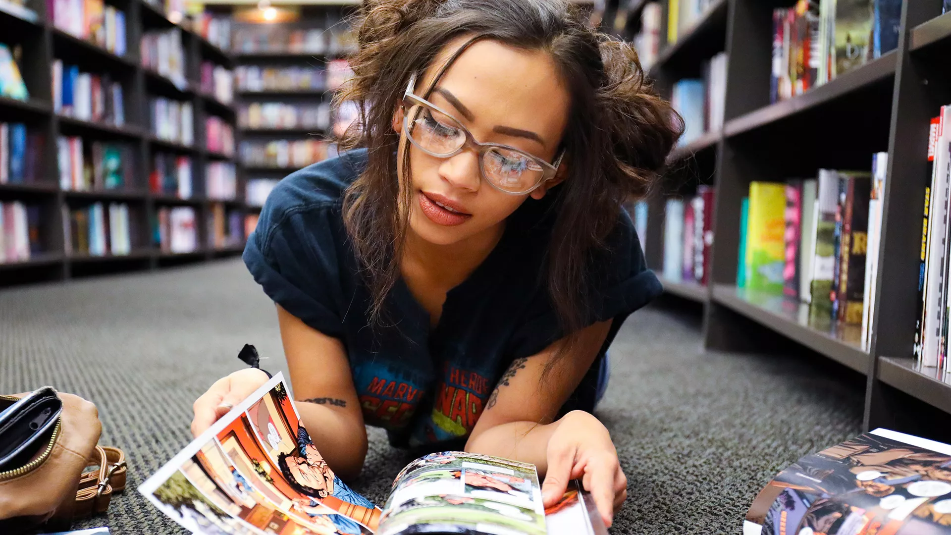 High school student reading graphic novel in the library