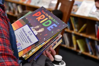 close up on person holding a stack of elementary books