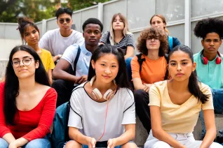 10 diverse high school students sit outside on a bench