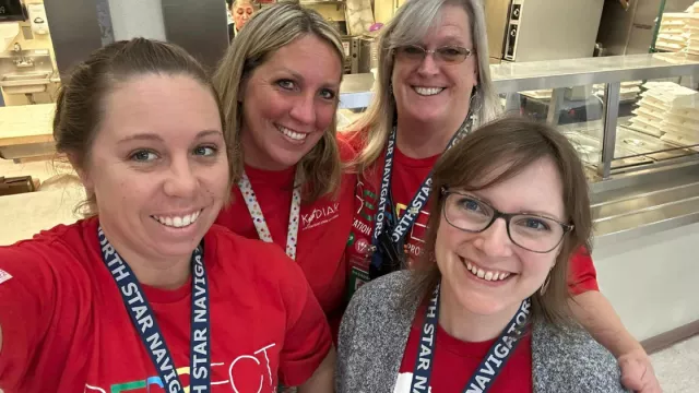 NEA-Alaska members pose for a selfie in a school cafeteria.