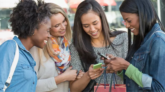 A group of educators looks at their phones in a circle
