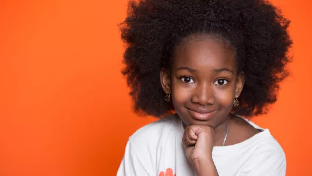 a young black girl with an orange background
