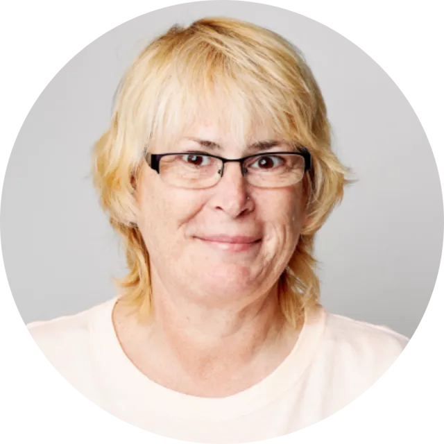 A portrait of a light-skinned woman with blonde hair and glasses